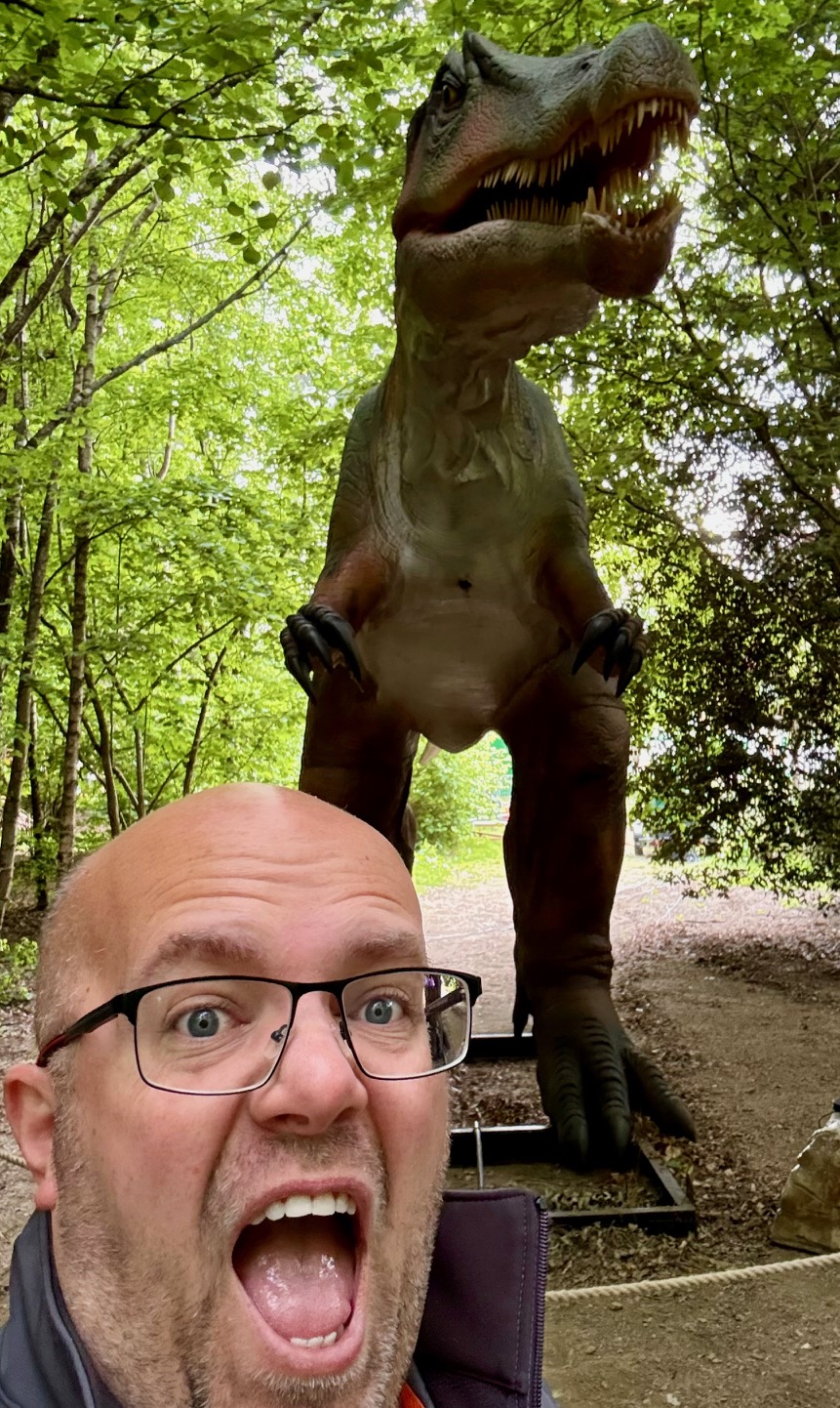 Dave Sammons taking a humorous selfie with a dinosaur